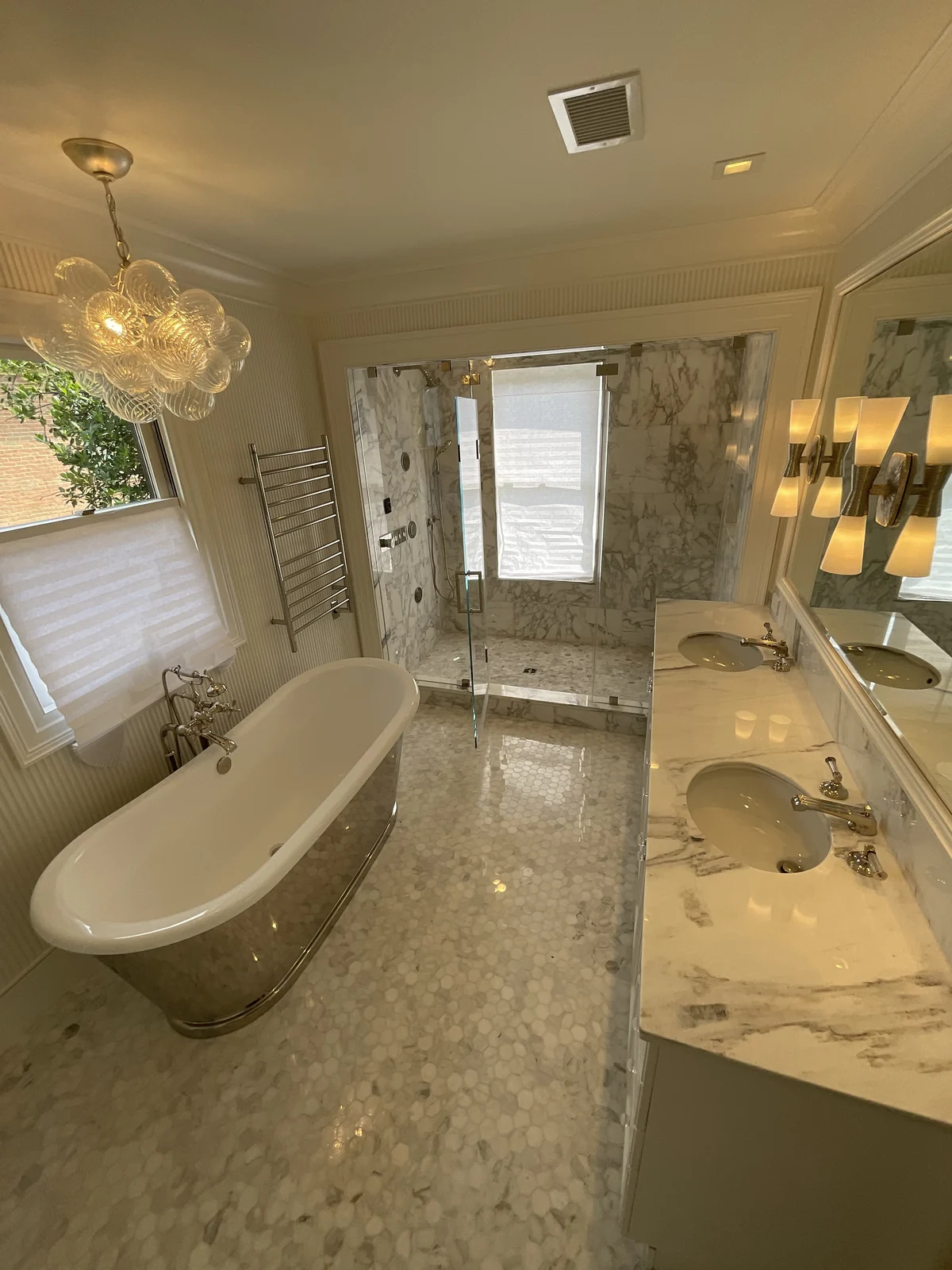 Bathroom with double vanity countertop, freestanding bathtub, tile floor and glass-enclosed shower