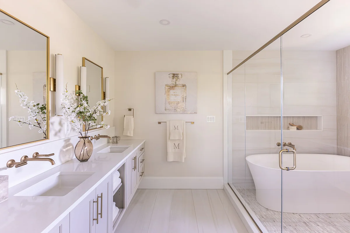 Bright bathroom with double vanity countertops and a glass-enclosed shower area with a wide niche.