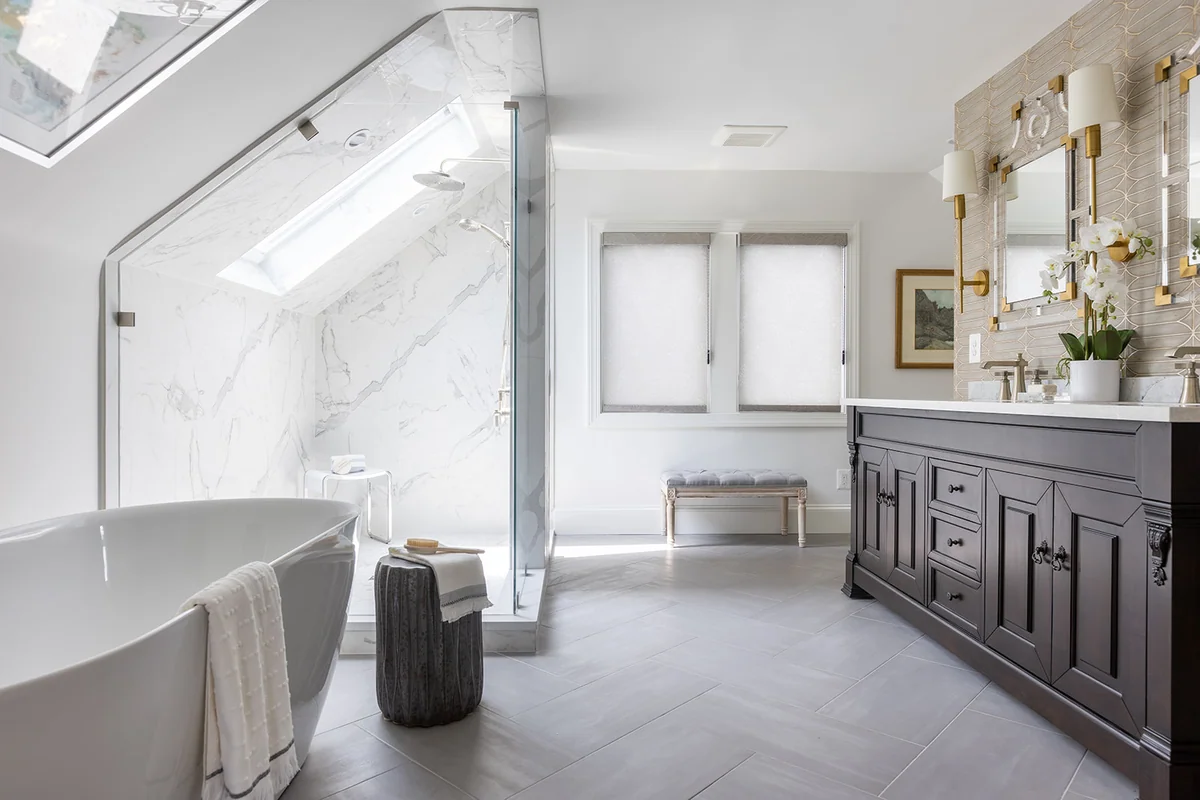 Bathroom with large-format porcelain shower walls and a herringbone porcelain floor beside a dark vanity.